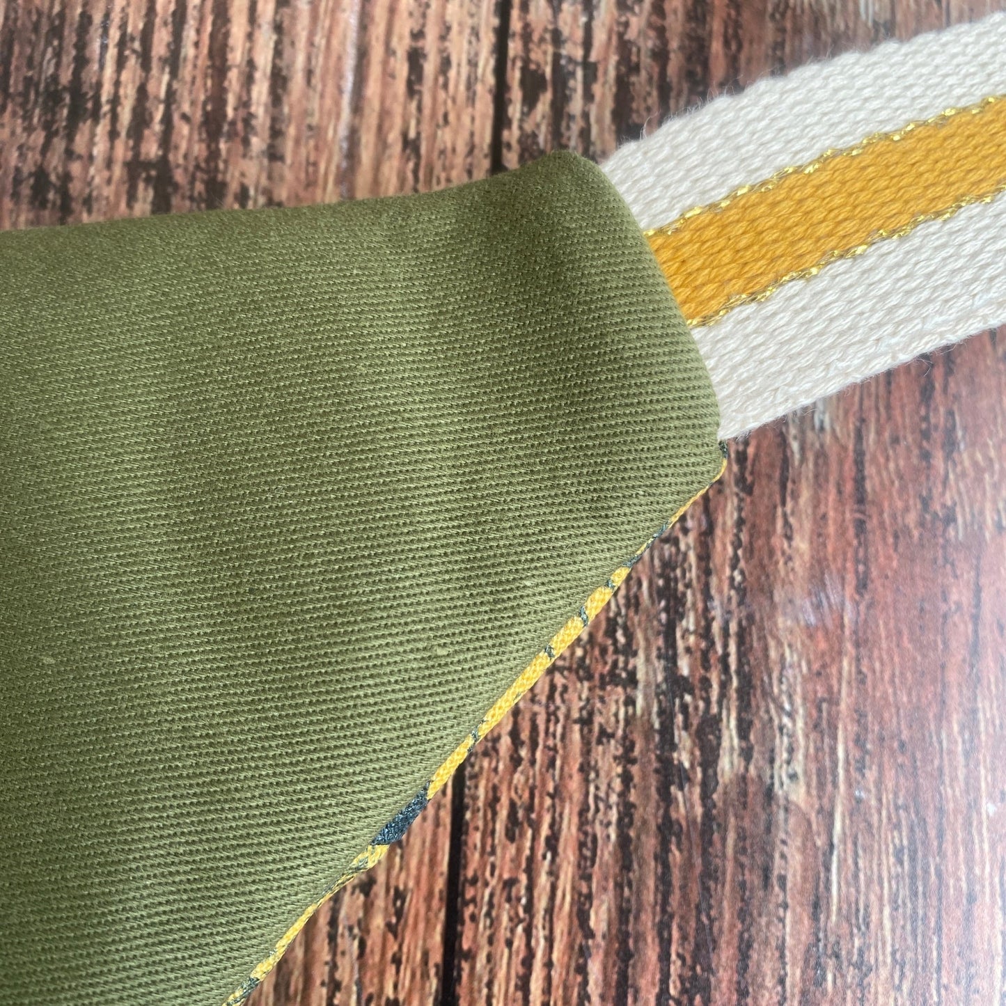Sac banane en tissu fleuri kaki, format XL. Détail du dos en coton uni kaki.