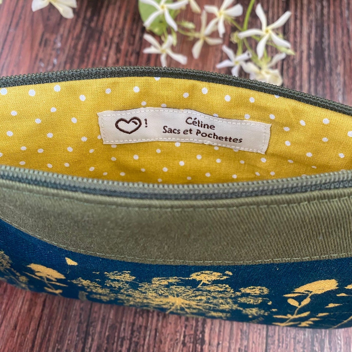 Doublure d'une pochette maquillage kaki en tissu fleuri, imprimée au cyanotype. Motifs végétaux révélés au soleil. Modèle fait main.