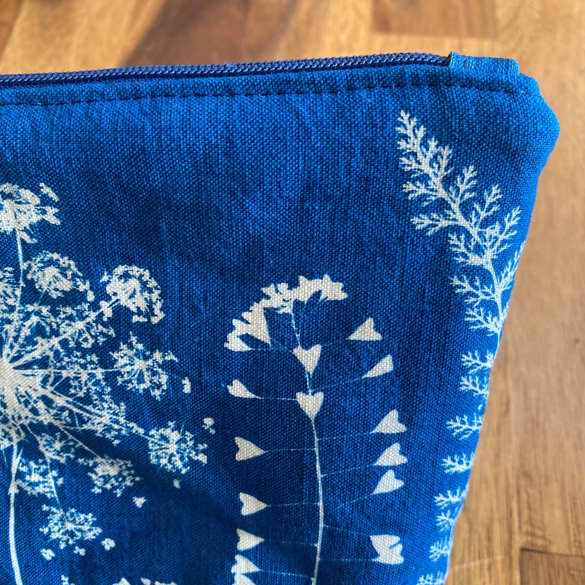 Zoom sur le zip de la petite pochette en tissu fait main avec impression de fleurs en cyanotype. Drap ancien collection Mamie Blue. 